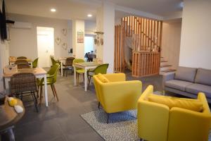 a living room with chairs and tables and a couch at Largo Bispo Boutique Hostel in Horta