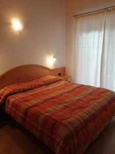 sypialnia z dużym łóżkiem i czerwonym kocem w obiekcie Villetta Muncion w mieście Pozza di Fassa