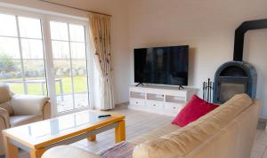 a living room with a couch and a flat screen tv at Heidehof Jungemann in Bispingen