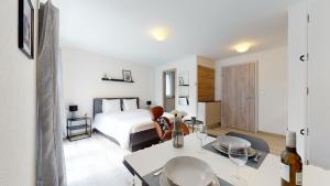 um quarto branco com uma cama e uma mesa em Nonanteneuf appart hōtel Aigle - contactless check-in em Aigle mais 37 fotografias