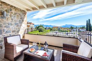 balcone con tavolo, sedie e vista di Warda C11 Apartment by Wonderful Italy a Desenzano del Garda