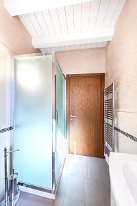 ein Badezimmer mit Dusche und Holztür in der Unterkunft Warda C11 Apartment by Wonderful Italy in Desenzano del Garda