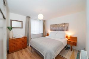 1 dormitorio con cama, escritorio y ventana en Abbotsford Apartment, en Dundee