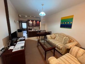 uma sala de estar com um sofá e uma mesa em Luxury Downtown Apartment - Gondola em Bansko