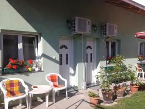 ein Haus mit zwei Stühlen und einem Tisch auf einer Terrasse in der Unterkunft Sobe Zlatna Greda in Novi Sad