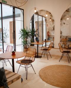 a restaurant with tables and chairs and large windows at Casa du Soleil in Madrid