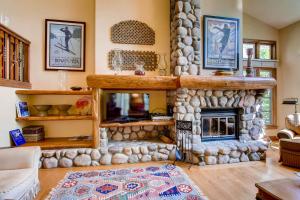 een woonkamer met een grote stenen open haard bij Highlands Area by East West Hospitality in Beaver Creek