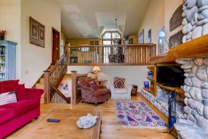 a living room with a red couch and a fireplace at Highlands Area by East West Hospitality in Beaver Creek