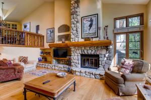 a large living room with a stone fireplace at Highlands Area by East West Hospitality in Beaver Creek