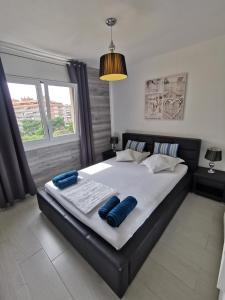 una camera da letto con un grande letto con cuscini blu di SANTA SUSANNA Sea Dreams Appartement - Bord de mer a Malgrat de Mar Altre 30 foto