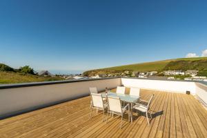 a patio with a table and chairs on a balcony at 1 Beachdown in Bigbury