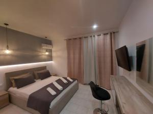 a bedroom with a bed and a table and a television at Aegean Pearl in Tigaki
