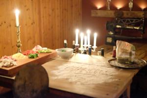 una mesa de madera con velas y comida. en Charming 6 bedroom House & Horse Farm - Sleeps 12, en Horndal