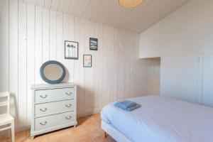 a bedroom with a bed and a mirror and a dresser at Maison Vue mer panoramique in Rivedoux-Plage