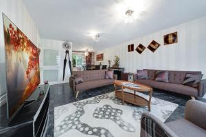 a living room with two couches and a tv at Suites by Rehoboth - Hendon Station - London in The Hyde