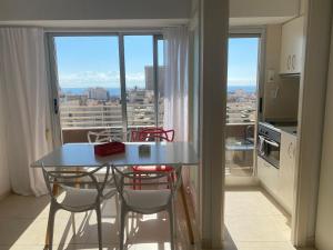 a table and chairs in a kitchen with a window at Apartamento Alicante & sea view in Alicante