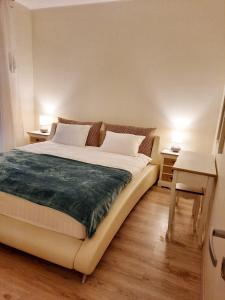a bed in a bedroom with two tables and two lamps at Sand Beach Apartment in Narva-Jõesuu