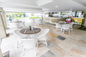 a restaurant with tables and chairs and a counter at Praia Brava Hotel - Apto 420 in Florianópolis
