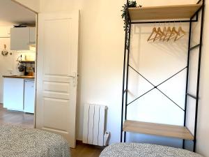 a bedroom with a glass door and a kitchen at Perle Marine au pied de la plage in Cabourg