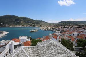 Blick auf eine Stadt und einen Hafen mit einem Boot in der Unterkunft Villea Seaview Apartments in Skopelos