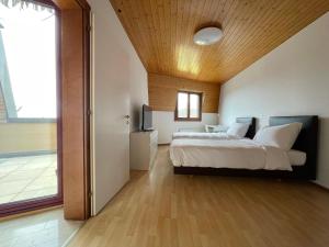 1 dormitorio con 1 cama grande y techo de madera en Third Floor en Etoy