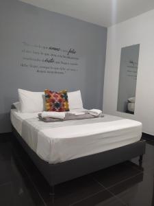 a bed in a room with a sign on the wall at Hotel Aura Medellin in Medellín