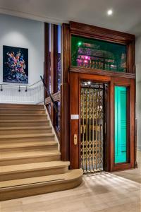 a lobby with a staircase with a gate and a door at Gladstone House in Toronto