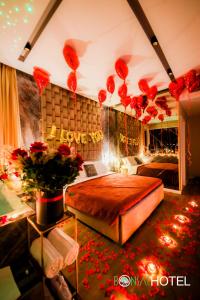 Hotel Bonsai في تيرانا: غرفة نوم بسرير مع ورود حمراء وبالونات