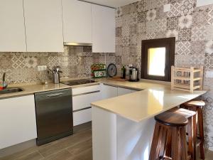 BoroxにあるSILBO RURALの白いキャビネットと黒い食器洗い機付きのキッチンが備わります。