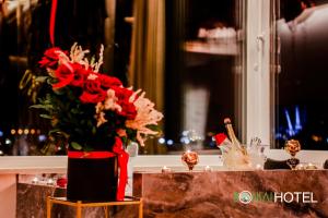 a vase filled with red flowers on a table at Hotel Bonsai in Tirana