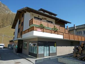 a building with a balcony on top of it at Ferienhaus Adonis in Saas-Grund
