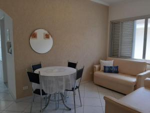 - un salon avec une table, des chaises et un canapé dans l'établissement Apto 1 dorm Guarujá, Enseada, 1 quadra da praia, à Guarujá