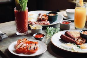 a wooden table topped with plates of food and drinks at The Knife & Cleaver in Houghton Conquest