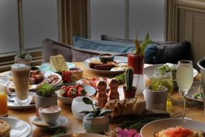 a table topped with plates of food and drinks at The Knife & Cleaver in Houghton Conquest