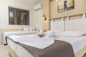two beds with white sheets in a bedroom at Villa Harmony in Agia Anna Naxos
