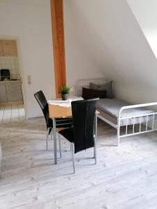 een eetkamer met een tafel en stoelen en een bed bij Monteurzimmer Apartment Katlenburg-Lindau FairWohnen24 All-Inkl 24h Check-In in Katlenburg-Lindau