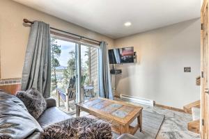 a living room with a couch and a table at Sunny Alpine Escape with Hot Tub and Mountain Vistas! in Fraser