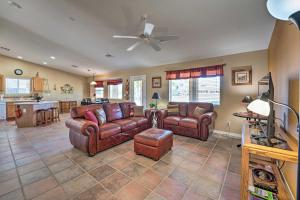 Fort Mohave Family Home with Golf Course Views! في Fort Mohave: غرفة معيشة مع أثاث جلدي ومروحة سقف
