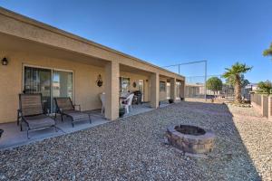 Fort Mohave Family Home with Golf Course Views! في Fort Mohave: فناء به كراسي ومدفأة امام المنزل
