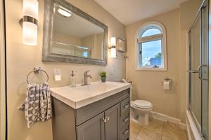a bathroom with a sink and a mirror and a toilet at Chic Manistee Cottage Steps to Lake Michigan! in Manistee +23 photos