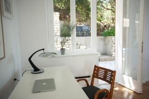 einem Tisch mit einem Laptop vor einem Fenster in der Unterkunft Villa The Spot in Zaostrog