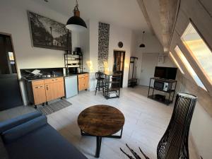 a living room with a couch and a table at Appartement 1 chambre Lili in Poligny