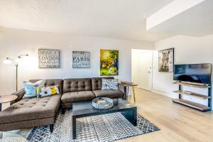 a living room with a couch and a tv at Hubble Place Condos in Seattle