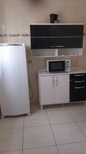 uma cozinha com um frigorífico branco e um micro-ondas em Casa Magnificat em São Tomé das Letras