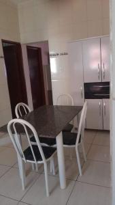 uma cozinha com uma mesa e cadeiras e um frigorífico em Casa Magnificat em São Tomé das Letras