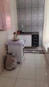 uma pequena cozinha com um lavatório e um balcão em Casa Magnificat em São Tomé das Letras