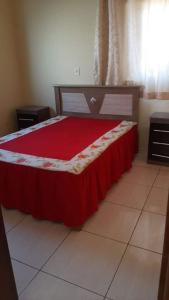 1 dormitorio con 1 cama con colcha roja en Casa Magnificat, en São Thomé das Letras
