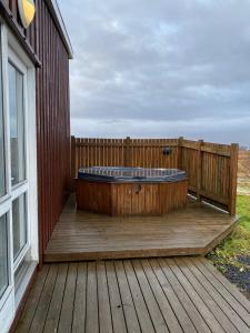 a hot tub sitting on a wooden deck at Skálholt Cottages in Selfoss