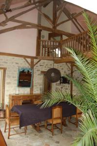 uma sala de estar com uma mesa e uma escada de madeira em Le Domaine du Crescent em Chezelles