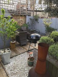 a small garden with a grill and some plants at Stunning 3 Bedroom House with Garden in Battersea in London